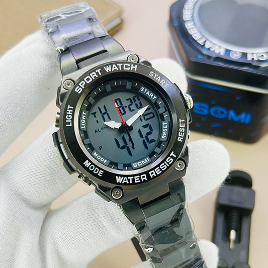 Digital sports watch with metal band held by a gloved hand, brand 'GOMI' visible in the background.
