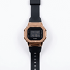 Casio G-Shock digital watch with rose-gold metal bezel and black silicone strap