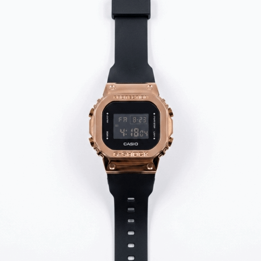 Casio G-Shock digital watch with rose-gold metal bezel and black silicone strap