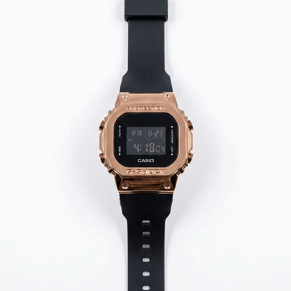 Casio G-Shock digital watch with rose-gold metal bezel and black silicone strap