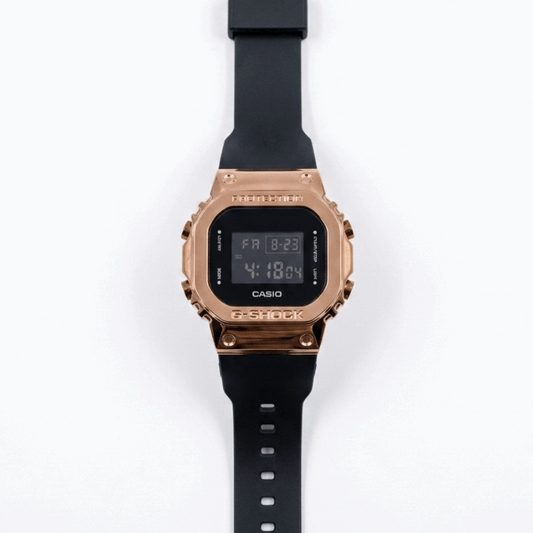 Casio G-Shock digital watch with rose-gold metal bezel and black silicone strap