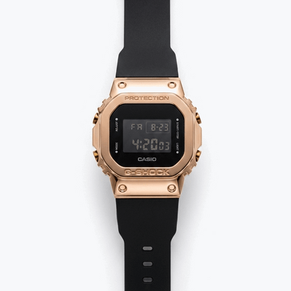 Casio G-Shock digital watch with rose-gold bezel, black strap, and LCD display