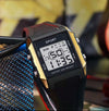 Square digital sport watch with black band, gold/silver case, LCD showing time