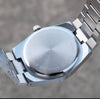 Stainless steel watch case back with engraved text and metal bracelet