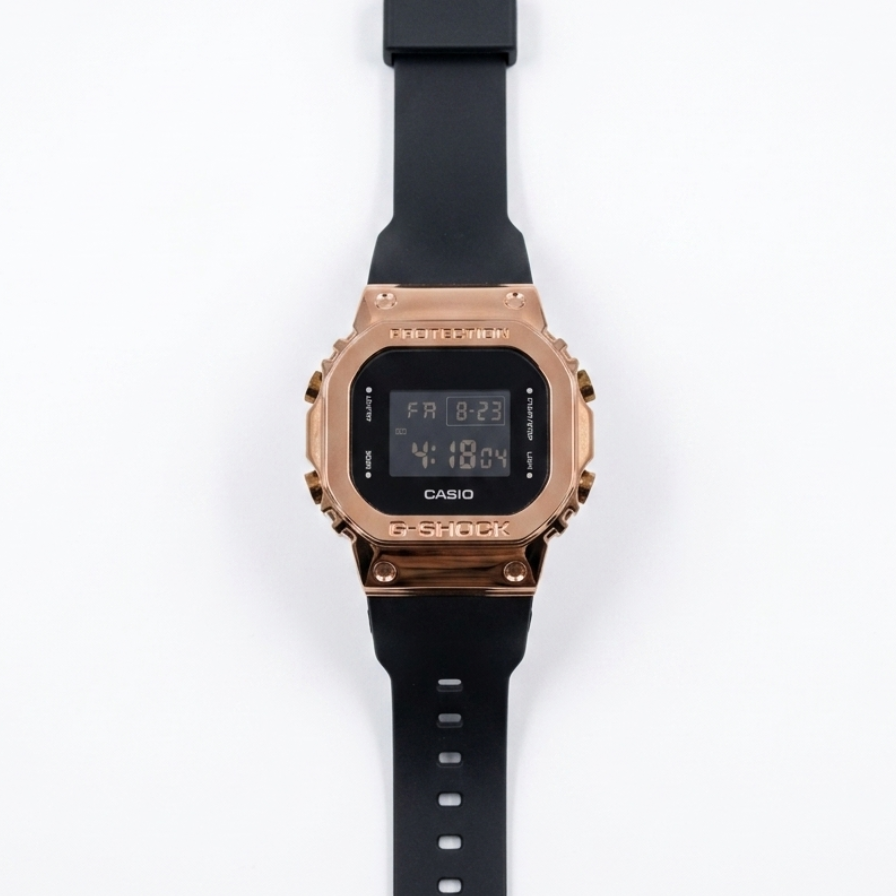Digital watch with rose gold bezel, black silicone strap, and LCD time display