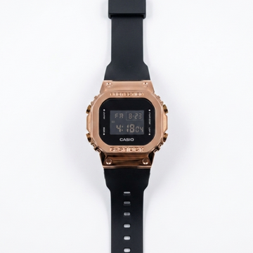 Digital watch with rose gold bezel, black silicone strap, and LCD time display