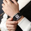 Black square digital watch with LCD screen on a wrist, rugged textured strap