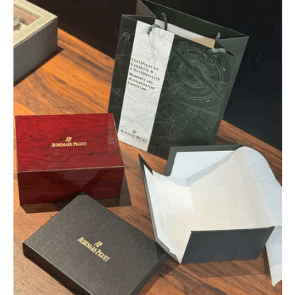 Watch box set with certificate, dark inner tray, and branded red outer box