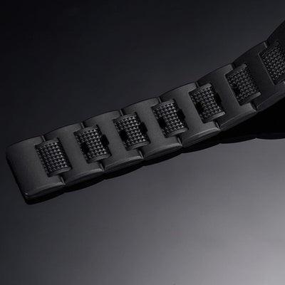 Black rubber watch strap close-up with textured segments and raised lug pattern