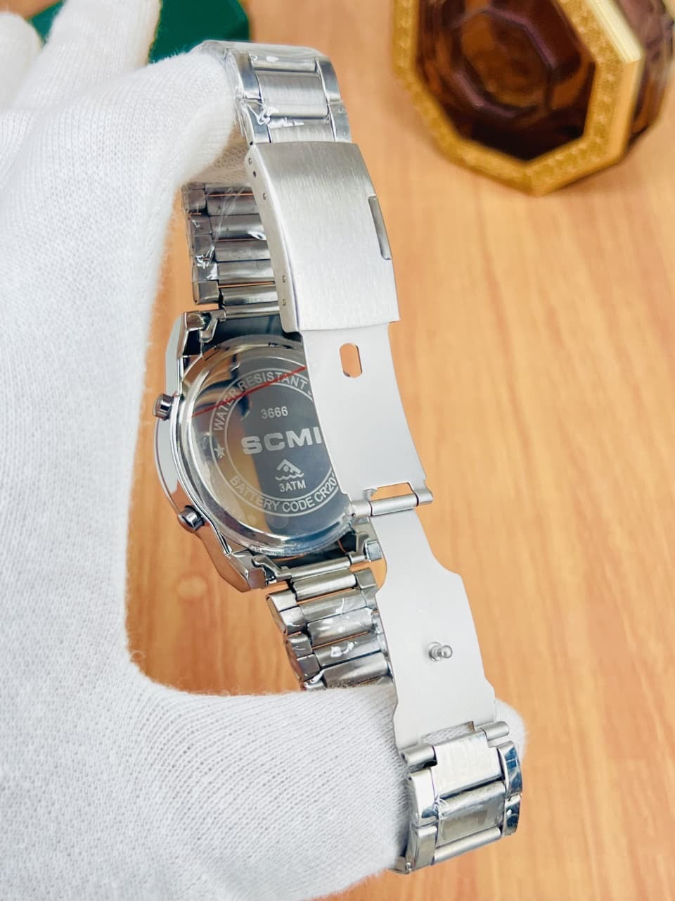 Digital alarm men's watch, silver metal band, side view with crown and buttons.