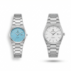 Pair of steel quartz wristwatches with light blue and light gray dials on metal bracelets